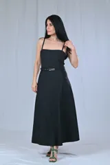 Vestido midi negro con breteles finos, corte ajustado en el torso y falda acampanada. Incluye cinturón con hebilla metálica.