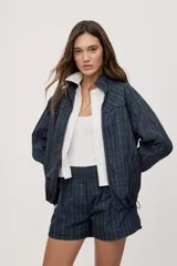 Campera liviana de calce relajado con estampado a cuadros en tonos de azul y verde. Cuenta con cuello alto, cierre frontal y mangas largas.
