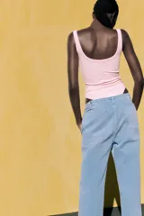 Body negro de escote redondo y tirantes anchos. Cierre inferior con botones a presión. Tejido de punto acanalado.