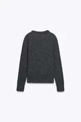 Jersey de punto de cuello redondo y manga larga, con acabados en rib en puños, cuello y bajo.