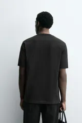 Camiseta de corte regular confeccionada en tejido de algodón compacto, con cuello redondo y manga corta.