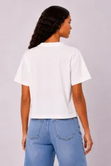 Remera manga corta de algodón color blanco, con cuello redondo y diseño holgado. Cuenta con estampado en el pecho de un paisaje de playa con palmeras en color verde.