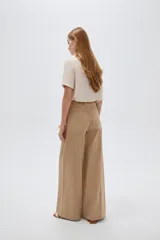 Pantalón jean verde militar, de tiro alto, corte ancho tipo wide leg y diseño de perneras amplias con costuras verticales decorativas.