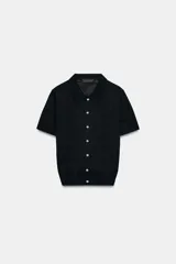 Chaqueta de punto negro de manga corta, con cuello solapa y cierre frontal con botones.