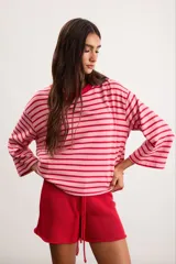 Remerón de algodón a rayas horizontales celestes y rojas, con silueta oversize, cuello redondo y mangas 3/4.