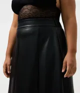 Falda midi de corte evasé confeccionada en cuero sintético (PU) de color negro. Presenta cintura estructurada con pasacintos y diseño de paneles verticales que aportan fluidez a la prenda.