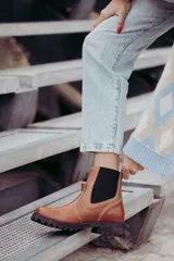 Bota tipo chelsea de cuero color marrón oscuro, con paneles laterales elásticos y suela track robusta con plataforma.