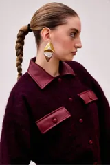 Chaqueta corta color burdeo confeccionada en alpaca y lana merino, con cuello y bolsillos de cuero.