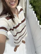 Vestido tejido de punto color beige con rayas horizontales en marrón y celeste, cuello polo con abertura en V y mangas cortas.