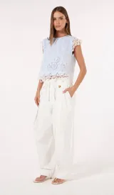 Musculosa celeste de guipur con bordados calados y detalles de encaje blanco en las mangas y en el ruedo.