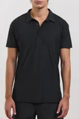 Chomba deportiva de manga corta, color negro, con cuello polo y cierre frontal de tres botones. Confeccionada en tejido técnico ultra liviano, fresco y respirable con alta elasticidad.
