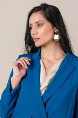 Blazer azul eléctrico de crepe y spandex, corte clásico, con solapas de muesca, cierre cruzado con botones forrados y bolsillos con solapa.