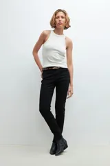 Pantalón de denim negro, corte slim, con cintura media y cierre frontal con botón y cremallera.