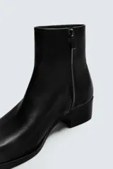 Bota de piel negra con cierre de cremallera lateral, horma cuadrada y tacón de 5 cm.