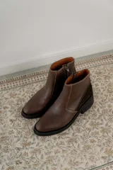 Bota corta de cuero marrón con panel trasero de gamuza en tono más oscuro, suela de goma negra y taco cuadrado bajo.