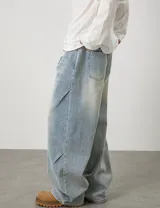 Jean baggy de tiro alto y lavado claro, con diseño amplio, pinzas y efecto desgastado en los muslos.