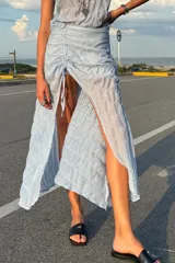 Conjunto de dos piezas en color amarillo, compuesto por un top sin mangas con textura plisada y una falda midi con frunce lateral ajustable que permite regular la abertura frontal.