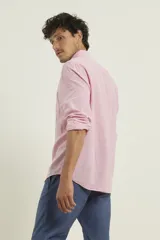 Camisa de manga larga confeccionada en una mezcla de algodón y lino, con cuello abotonado, cierre frontal de botones y un bolsillo en el pecho.