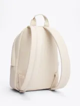 Mochila Tommy Jeans color crema, de poliuretano, con cierre de cremallera, asa superior y correas ajustables y acolchadas. Tiene un compartimento principal, un bolsillo interior de malla y un bolsillo exterior con cremallera.