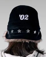 Gorra de pana negra con orejeras forradas en piel sintética y visera plana. Presenta un bordado frontal con el nombre de la marca Twojeys, estrellas y texto decorativo en color blanco.