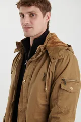 Campera de abrigo estilo parka, color verde militar, con capucha desmontable, cierre frontal con botones y múltiples bolsillos funcionales en pecho, cintura y manga.