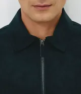 Campera Harrington de gamuza sintética color verde oscuro, de manga larga, con cuello camisero y cierre frontal completo.