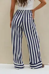 Pantalón largo de corte ancho, con diseño de rayas verticales en azul marino y blanco. Cuenta con cintura elástica fruncida y cordón ajustable blanco.