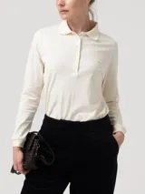 Remera de manga larga tipo polo confeccionada en piqué de algodón pima, con cuello camisero, tapeta con botones tono a tono y puños ajustados. Presenta un parche bordado con forma de pato en el pecho.