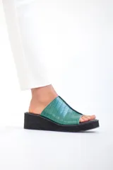 Sandalia de cuero vacuno color verde esmeralda con plataforma corrida baja y punta cuadrada.