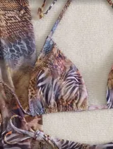 Conjunto de bikini con estampado animal print, compuesto por un corpiño triangular con tirantes finos y una falda larga de corte recto con abertura lateral.
