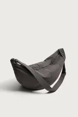 Bolso de hombro tipo hobo de nylon negro, con diseño curvo y asa ajustable. Cuenta con compartimento principal con cierre de cremallera y bolsillo interior con cremallera.