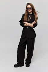Blazer sastrero negro de calce relajado, con solapa clásica, cierre de un botón frontal y bolsillos laterales con tapa.