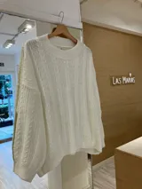 Sweater blanco de tejido de punto con diseño de ochos, cuello redondo y corte holgado.