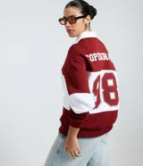 Saco de tejido de punto color bordó y blanco, con cuello polo blanco y tapeta de botones. Presenta un estampado de texto en el pecho.