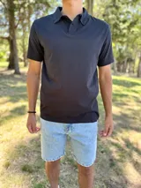 Remera polo de manga corta en color negro, con cuello camisero y cierre frontal de botones.