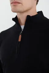 Sweater verde oliva de tejido acrílico con textura similar al cashmere, corte clásico, cuello alto con cierre metálico y tirador de cuerina ecológica.