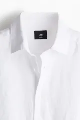 Camisa H&M de lino liviano color blanco, de corte entallado slim fit, con cuello italiano y manga larga.