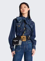 Cartera bandolera Balmain modelo B-Army confeccionada en lona y cuero color negro con estampado geométrico blanco. Tiene correa de cadena dorada y cierre con cremallera.