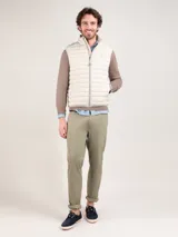 Chaleco gris acolchado para hombre, confeccionado en nylon reciclado repelente al agua, con cierre de cremallera, sisa elástica y logo engomado en el pecho.