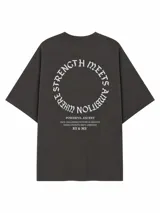 Remera de corte oversize color gris claro, con cuello redondo y mangas cortas. Presenta múltiples estampados gráficos en el frente con tipografías variadas y el logo de la marca en la parte inferior.