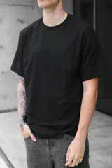 Remera negra de corte oversized con estampado en el centro de la espalda con la palabra "Strength" en tipografía cursiva con efecto de luces.