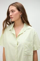 Camisa de manga corta de algodón con diseño a rayas en tonos amarillo y blanco, calce holgado, cuello solapa y bolsillo aplicado en el pecho.