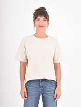 Remera de algodón blanca, de corte holgado y cuello redondo, con mangas cortas de diseño clásico.