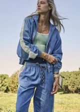 Chaqueta con cremallera color celeste con paneles blancos en las mangas.