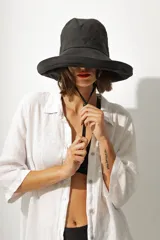 Vestido corto de cuero negro, sin mangas y con cuello redondo. Presenta un corte ajustado al cuerpo.