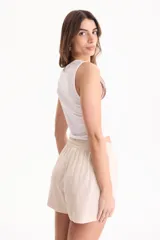 Top blanco sin mangas de algodón, con diseño corto y ajuste ceñido al cuerpo.