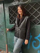 Chaqueta negra con cuerpo de cuero, mangas de tejido de punto y cuello de lana.