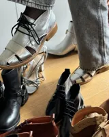 Zapato acordonado de cuero vacuno color marrón con aberturas laterales y cordones negros.