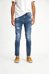 Pantalón de jean azul de corte ajustado con roturas en las rodillas.