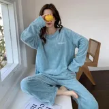 Conjunto de pijama de dos piezas confeccionado en tela de plush texturizada con diseño de rayas verticales en relieve. Incluye una remera de manga larga con cuello redondo y un pantalón de corte holgado. La remera presenta un pequeño bordado decorativo en el pecho.